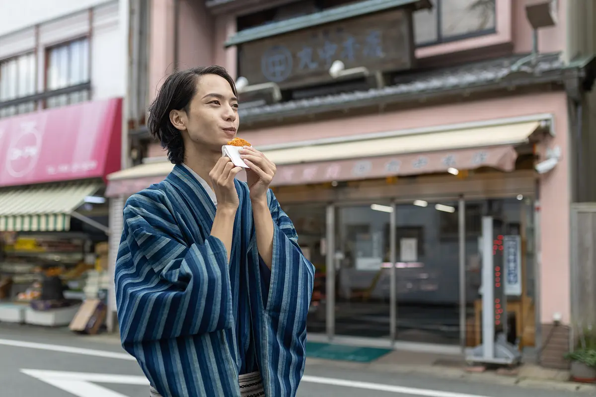 ミンチカツを食べ歩きする松田さん