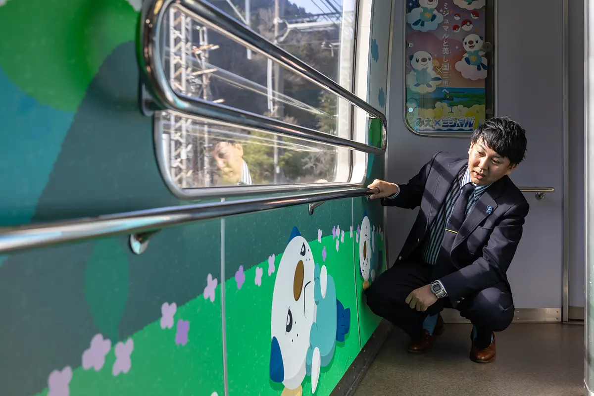 ミジュマルライナーでミジュマルのイラストを眺める寺家さん