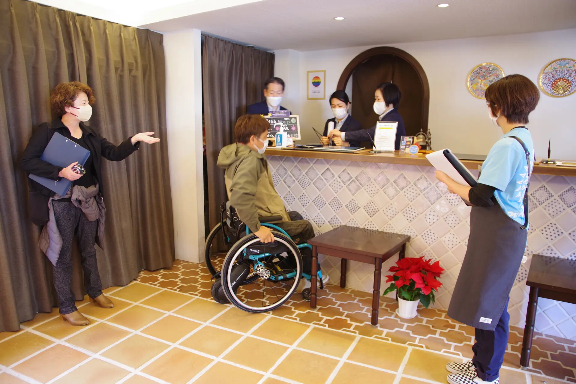 車いすの方からアドバイスを受けているホテルスタッフ