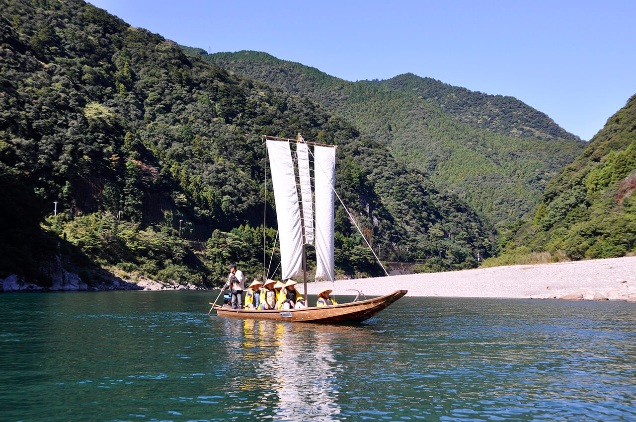 Three tan sails on the Kumano River